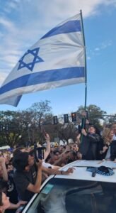 Milei fotografato mentre sventola una bandiera di Israele. Il nuovo presidente ha dichiarato di voler spostare la ambasciata argentina da Tel Aviv a Gerusalemme
